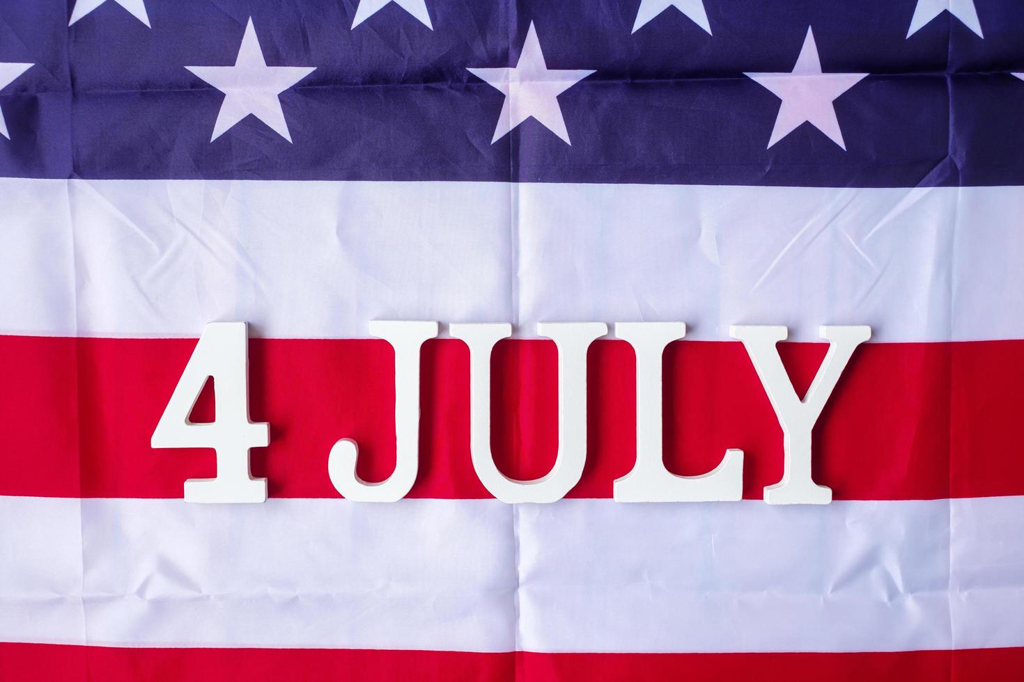 Fourth of July text on United States of America flag background. USA holiday of Independence and celebration concepts photo