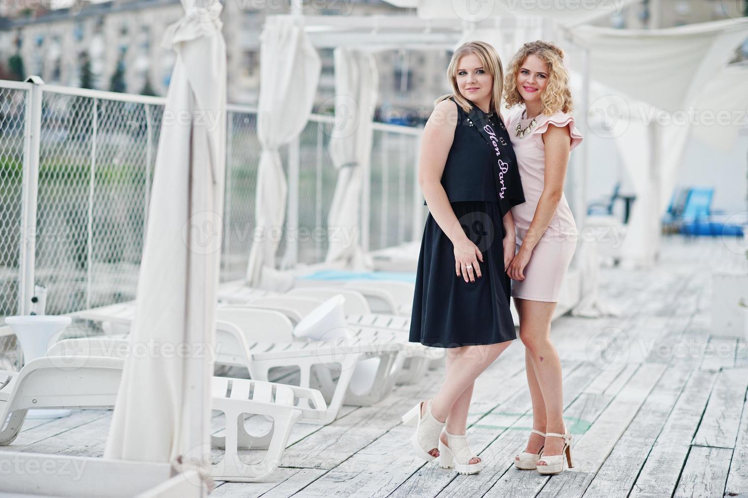 Two girls posed at hen party on the pier of beach. photo