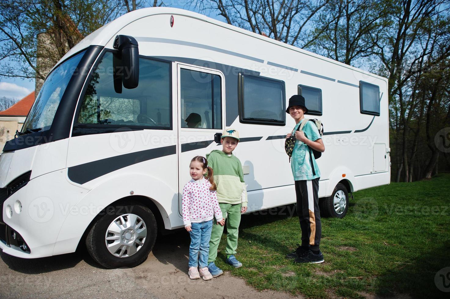 Children travel at motorhome RV camper van at parking. photo