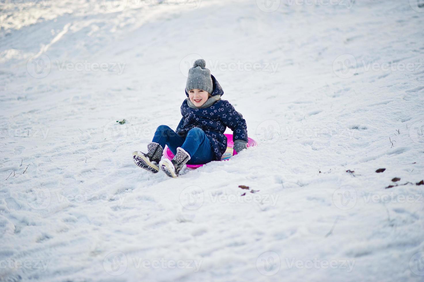 Cute little girl with saucer sleds outdoors on winter day. photo