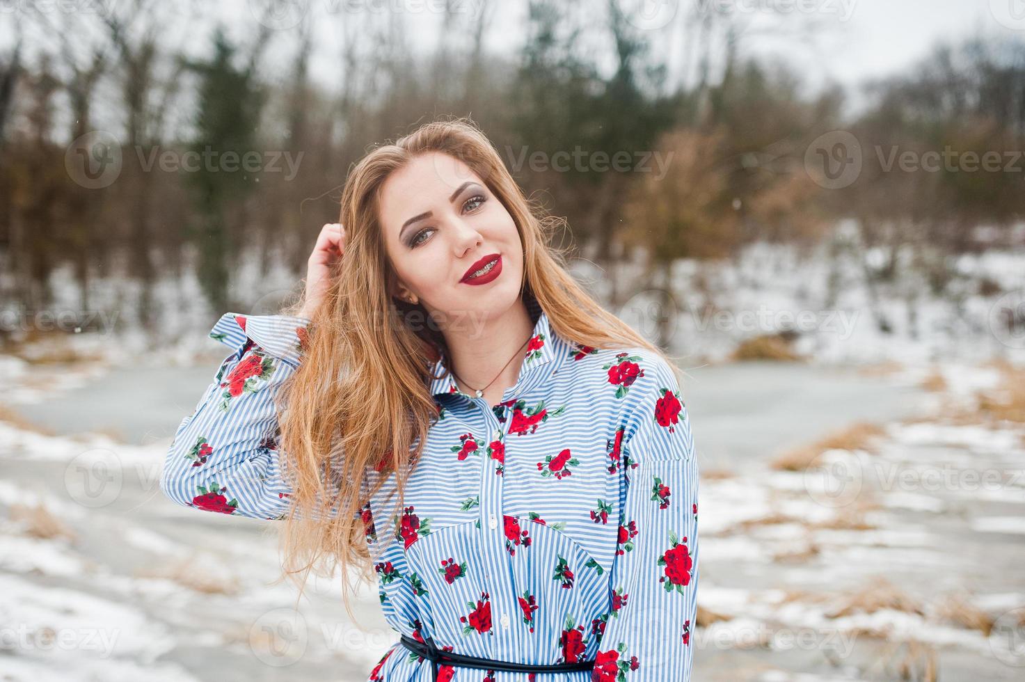 Girl with braces at winter day against frozen lake. photo