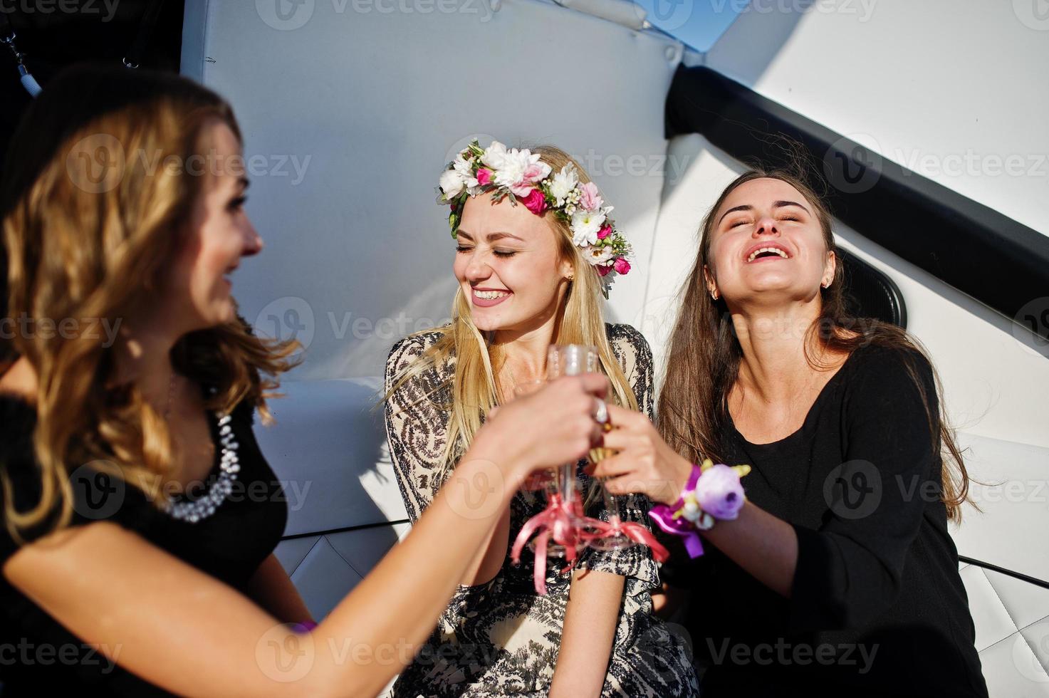 Girls drinking champagne at yacht on hen party. photo