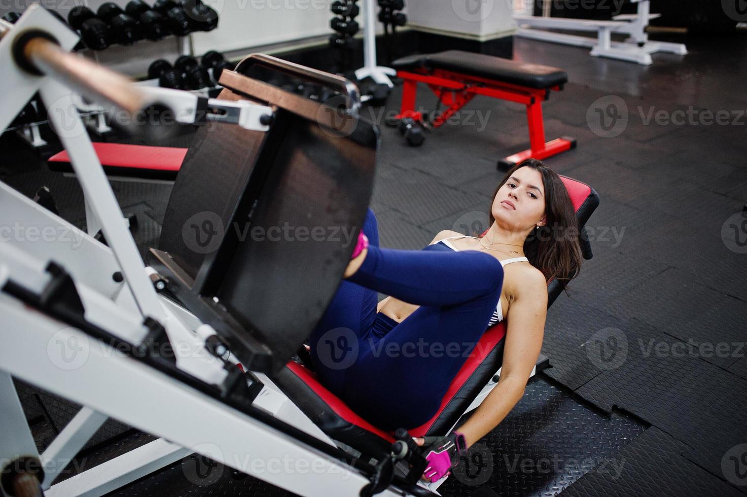 Young beautiful woman doing exercises  and working hard in gym and enjoying her training process. photo