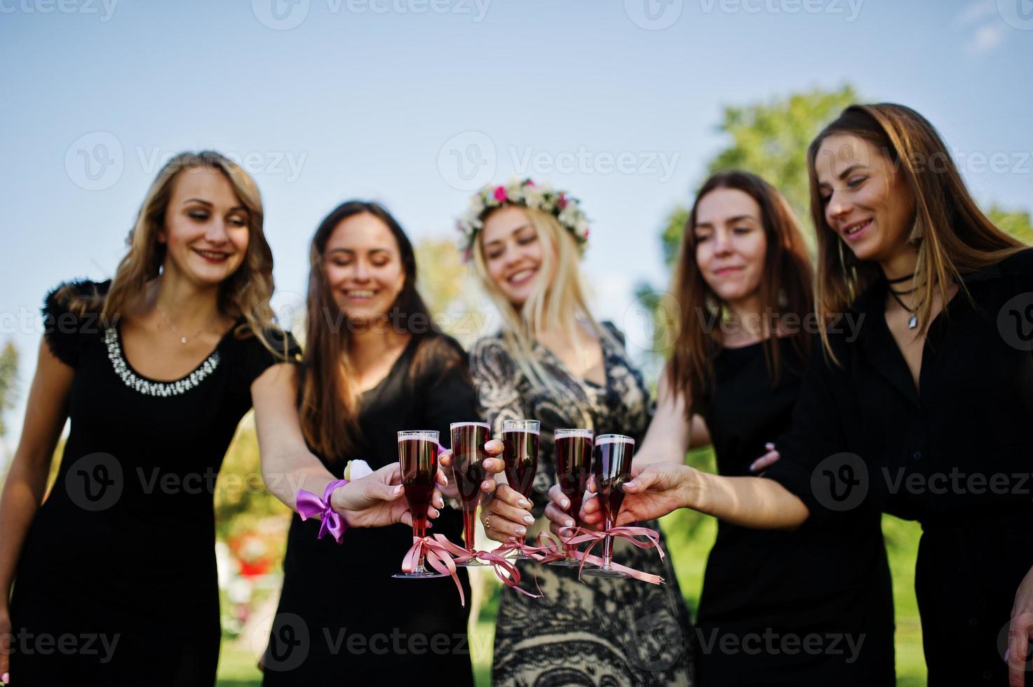 Five girls wear on black with balloons drinking red champagne at hen party. photo