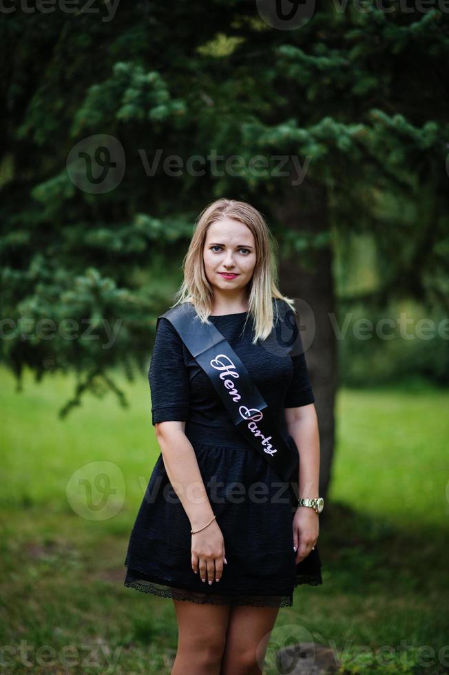 Portrait of gorgeous girl wear on black at hen party, posed at park. photo