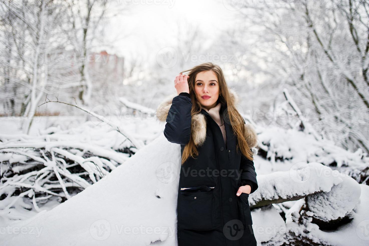 Beautiful brunette girl in winter warm clothing. Model on winter jacket. photo