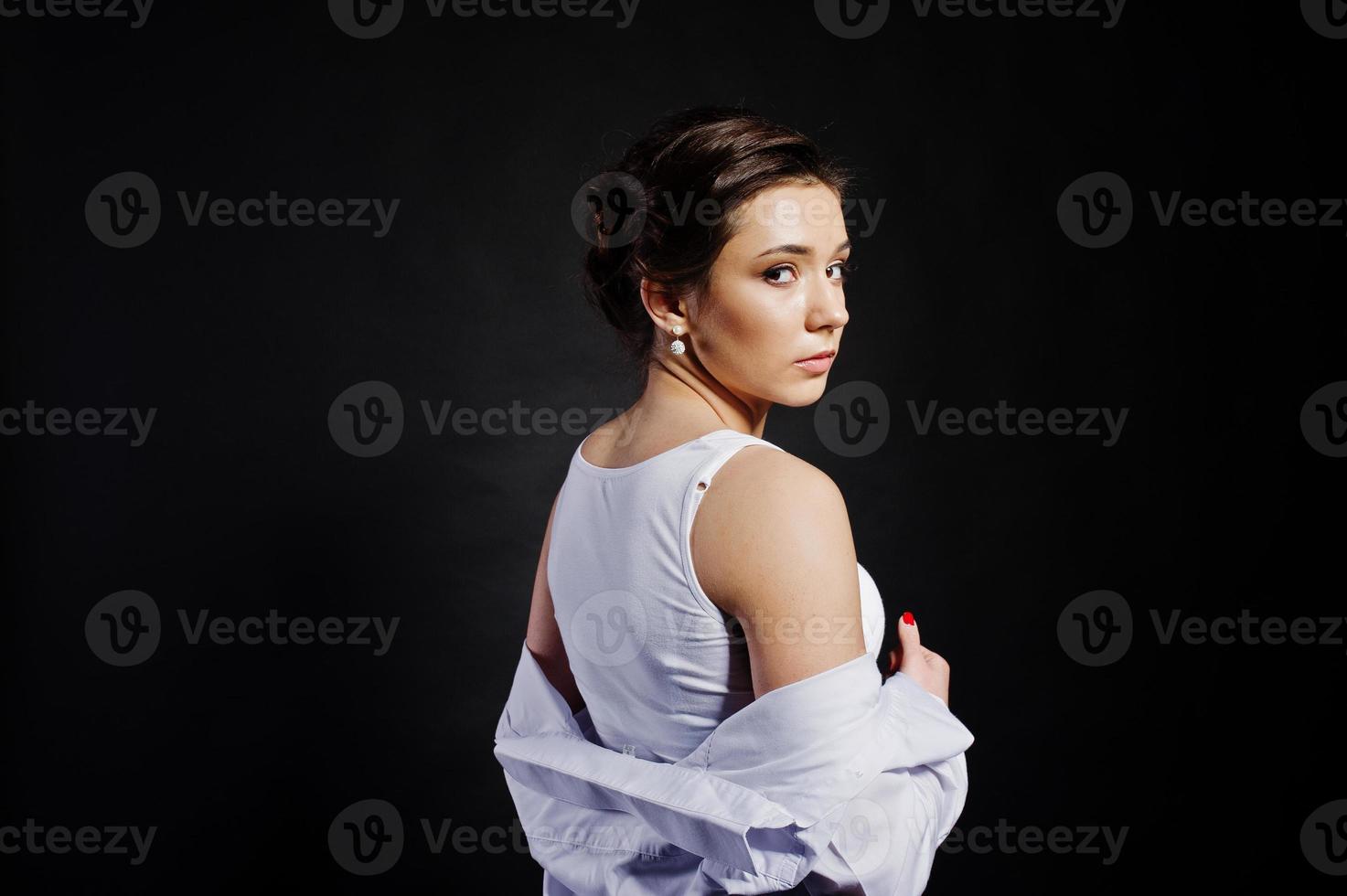 retrato de estudio de una chica morena con maquillaje sobre fondo negro. foto