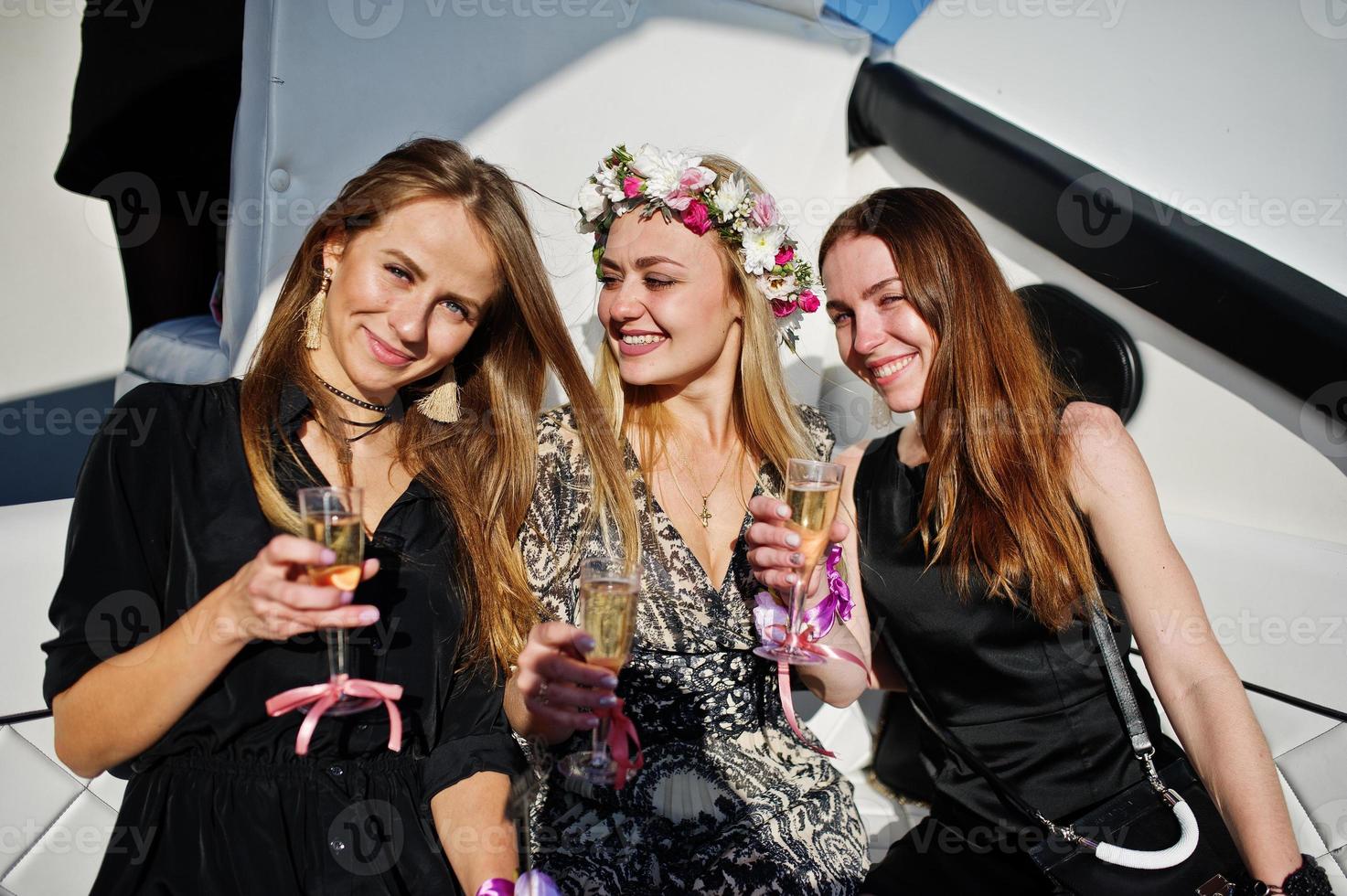 Girls drinking champagne at yacht on hen party. photo