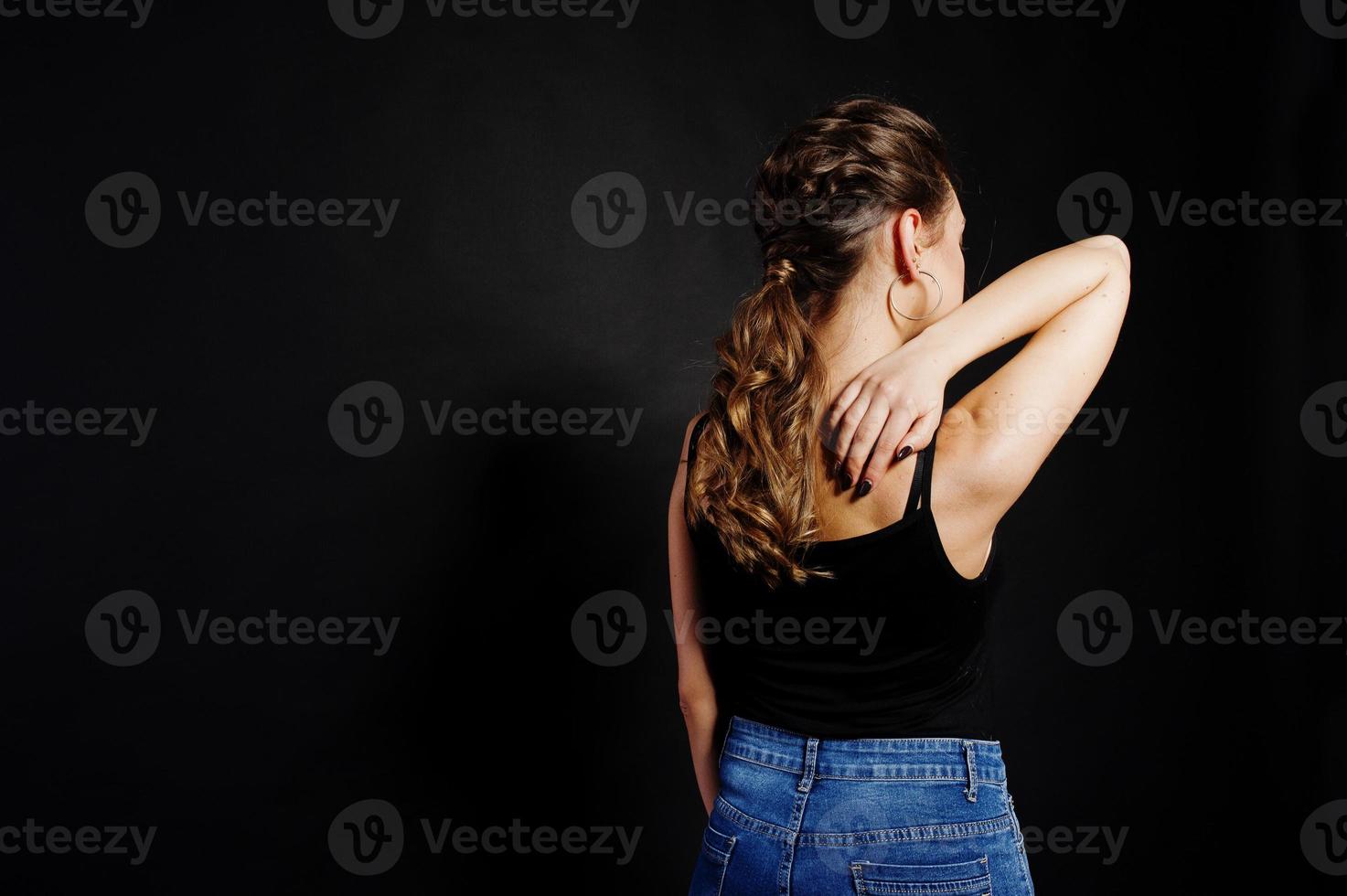 Studio portrait of back hairdress brunette girl  on black background. photo