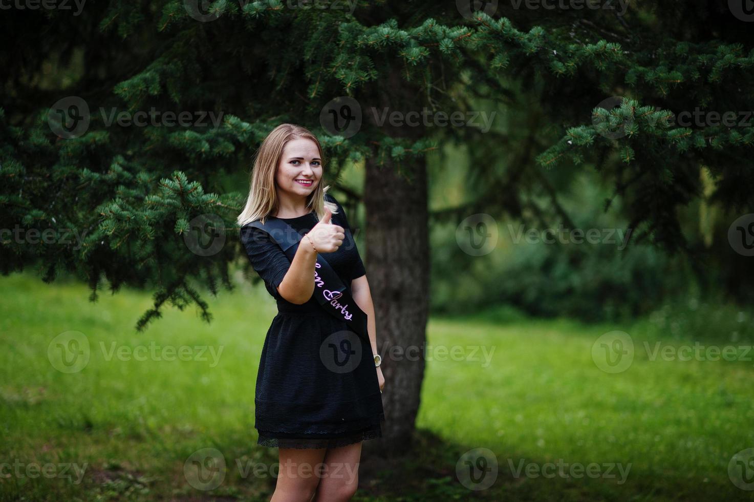 Portrait of gorgeous girl wear on black at hen party, posed at park. photo