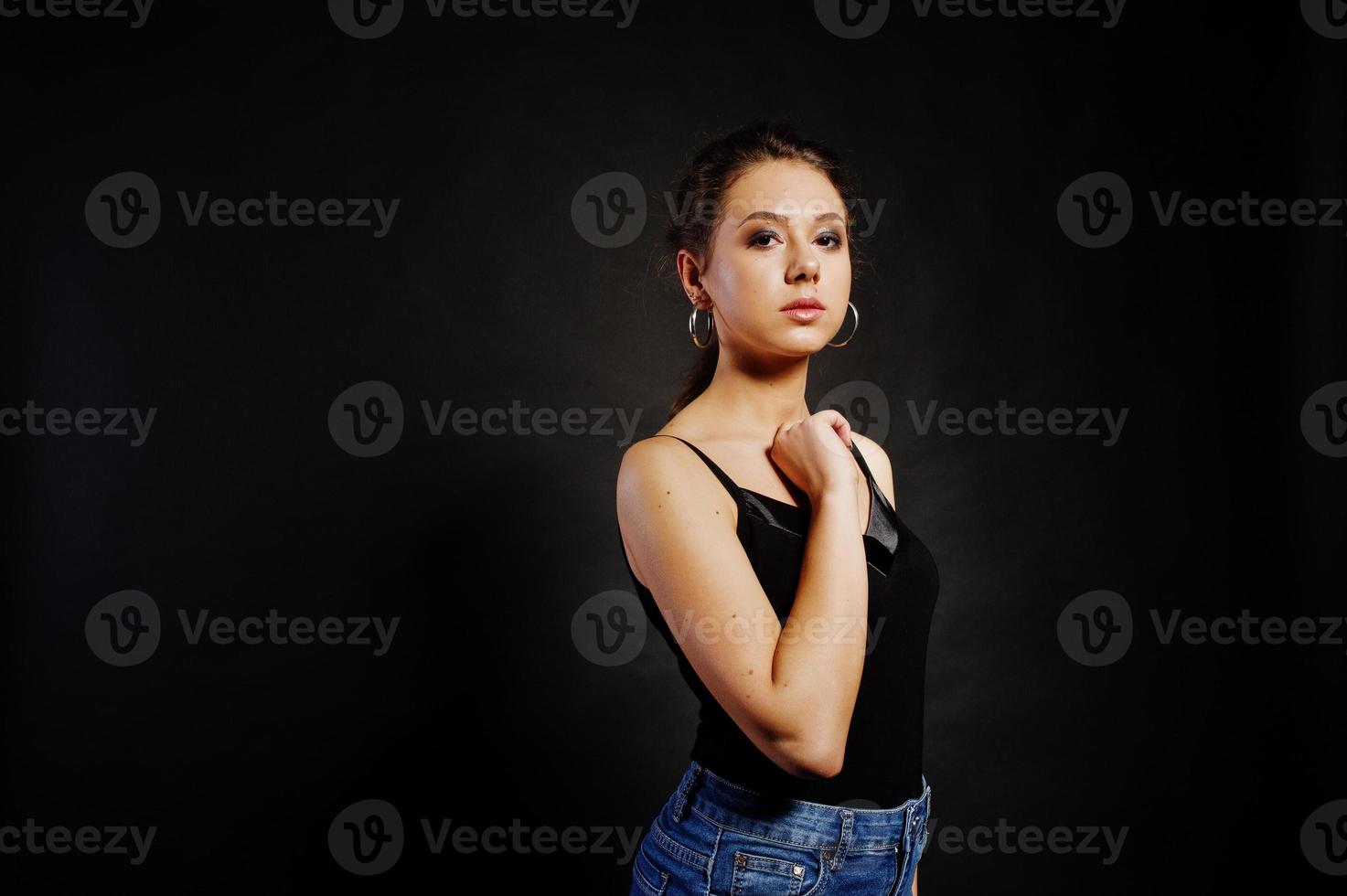 Studio portrait of brunette girl with make up on black background. photo