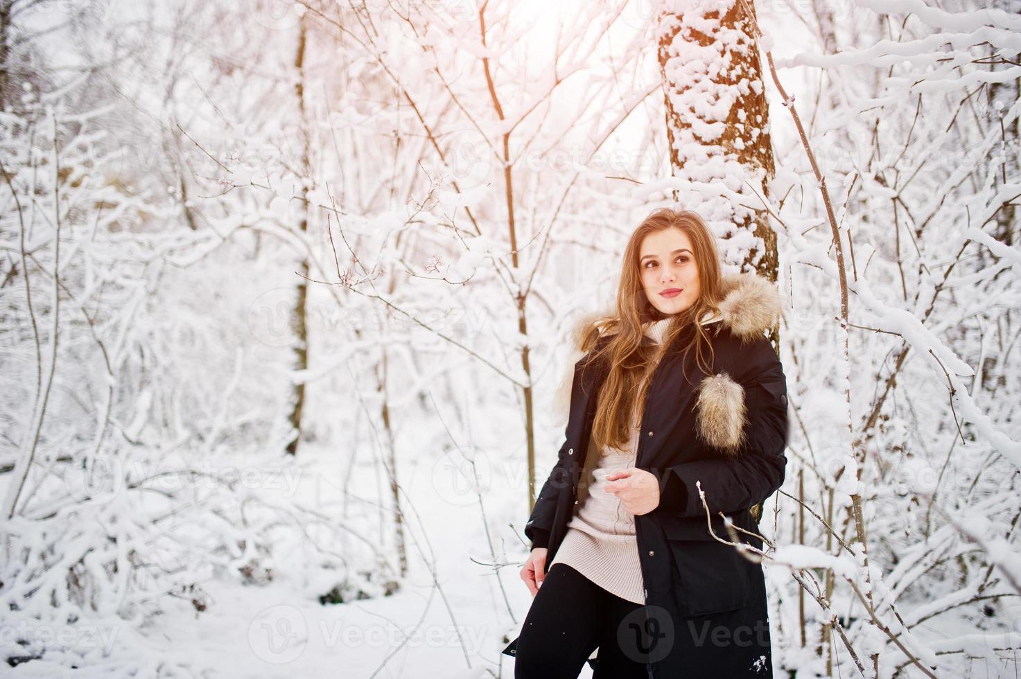 Beautiful brunette girl in winter warm clothing. Model on winter jacket. photo