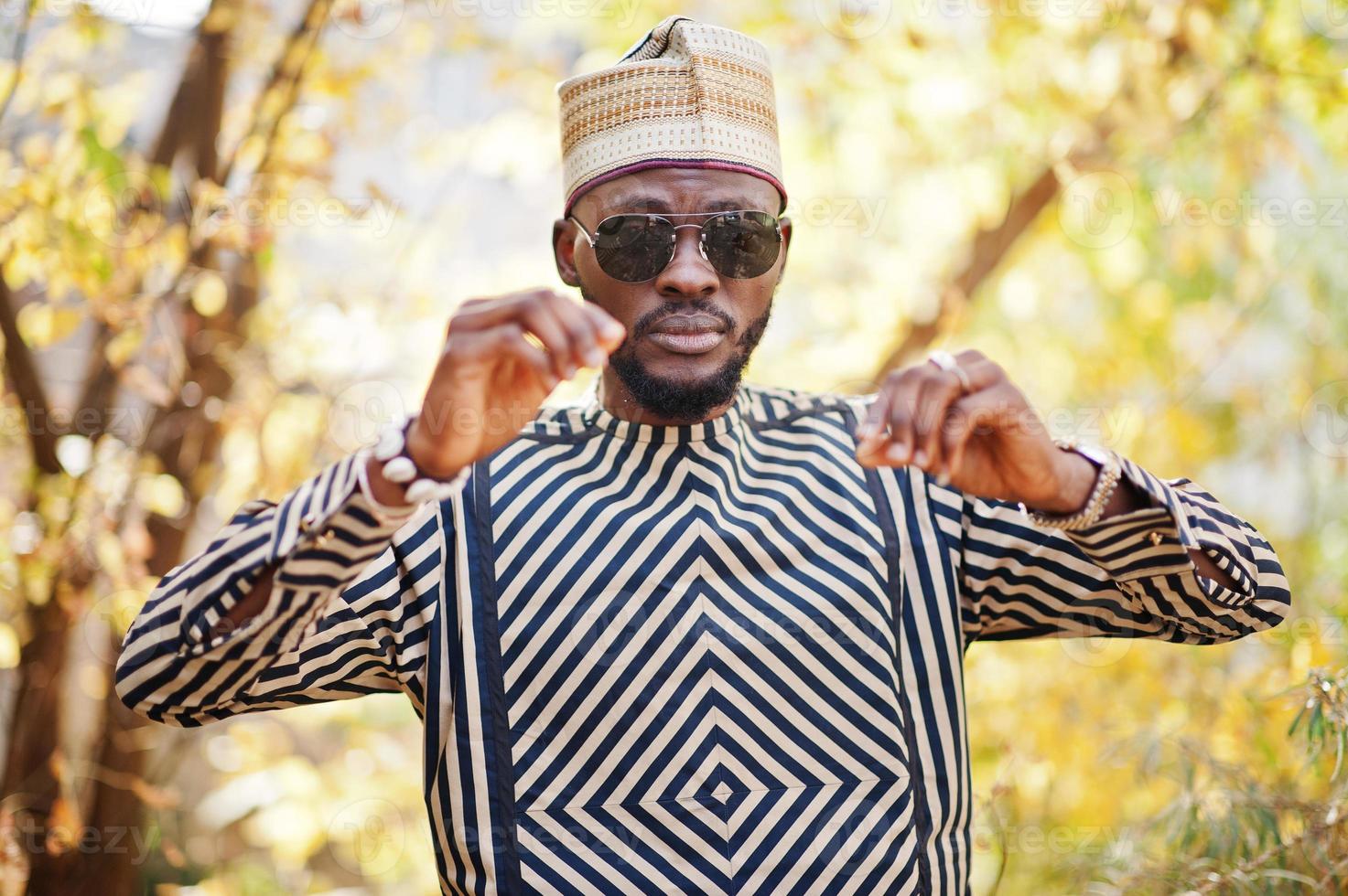 Portrait of stylish black african american man at hat and sunglasses against sunny autumn fall background. photo