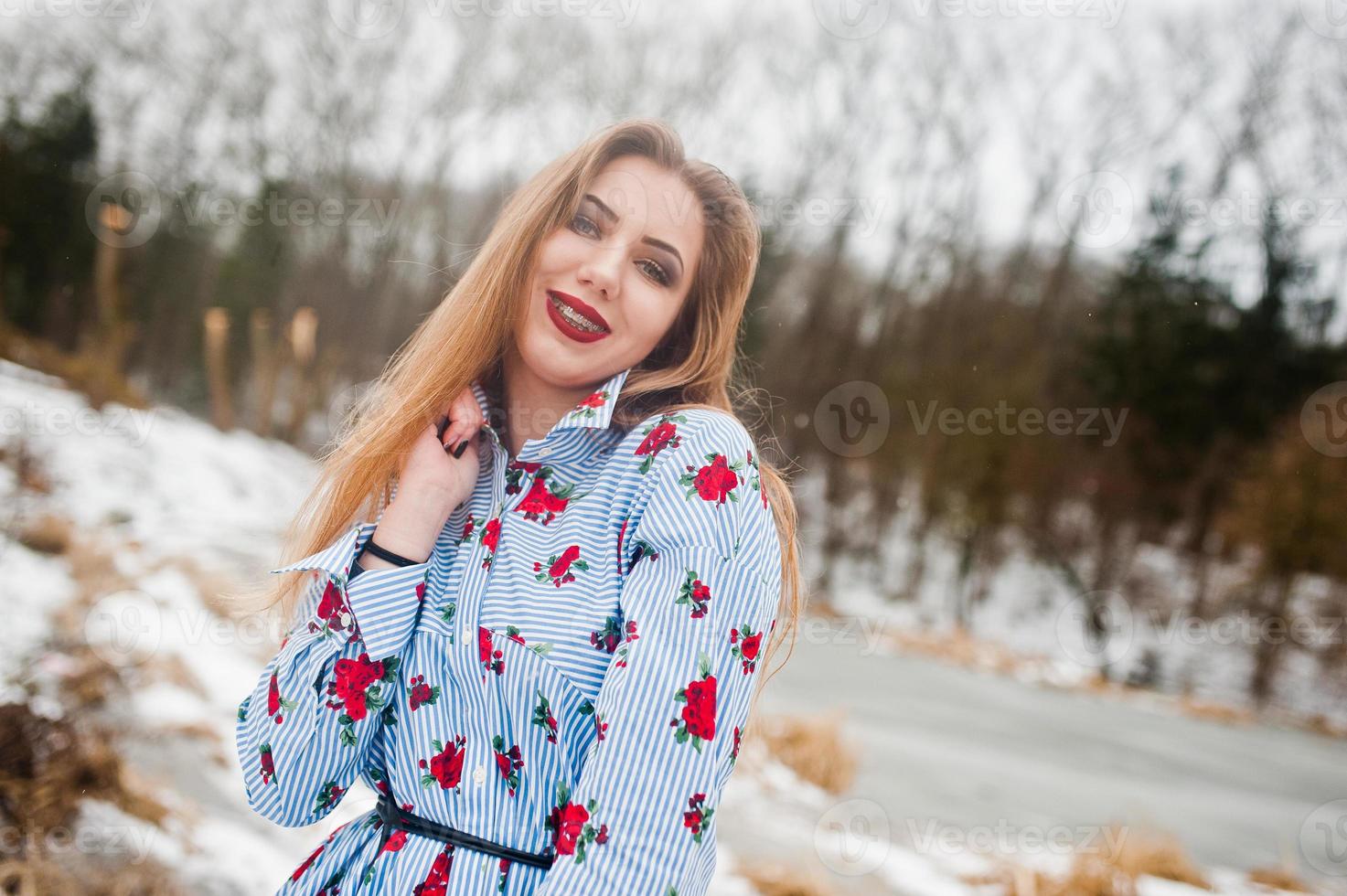 Girl with braces at winter day against frozen lake. photo