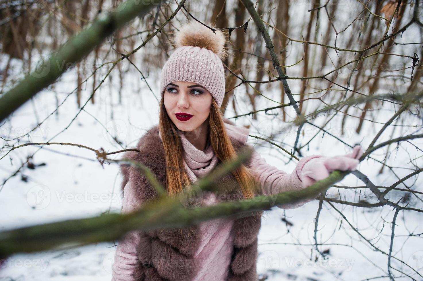 Stylish girl in fur coat and headwear at winter forest. photo