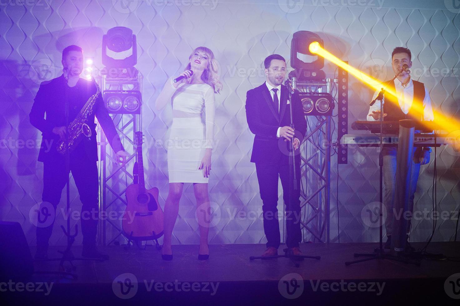 banda de música musical en vivo actuando en un escenario con diferentes luces. foto