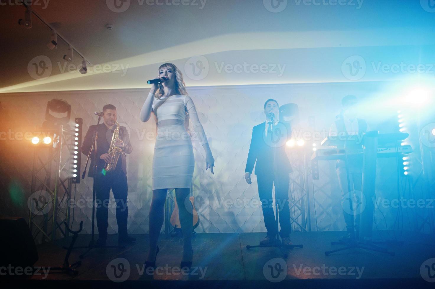 banda de música musical en vivo actuando en un escenario con diferentes luces. foto