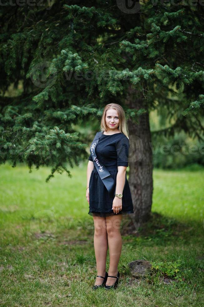 Portrait of gorgeous girl wear on black at hen party, posed at park. photo