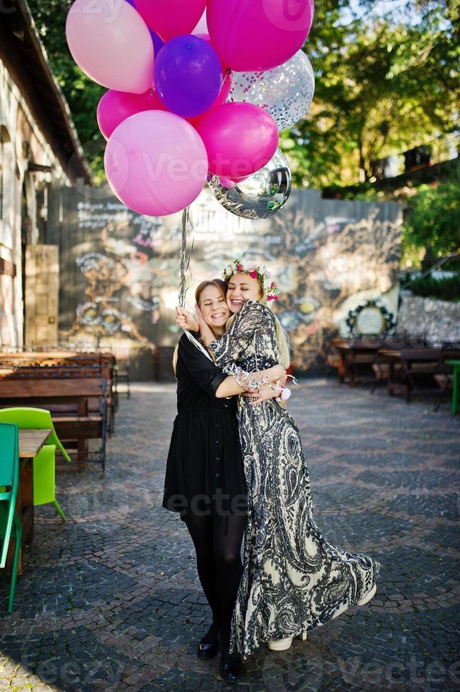 Two girls wear on black with balloons at hen party. photo