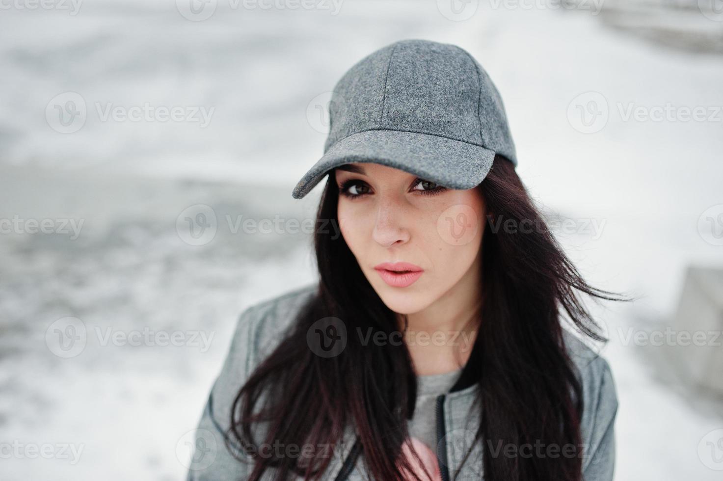 Stylish brunette girl in gray cap, casual street style on winter day. photo