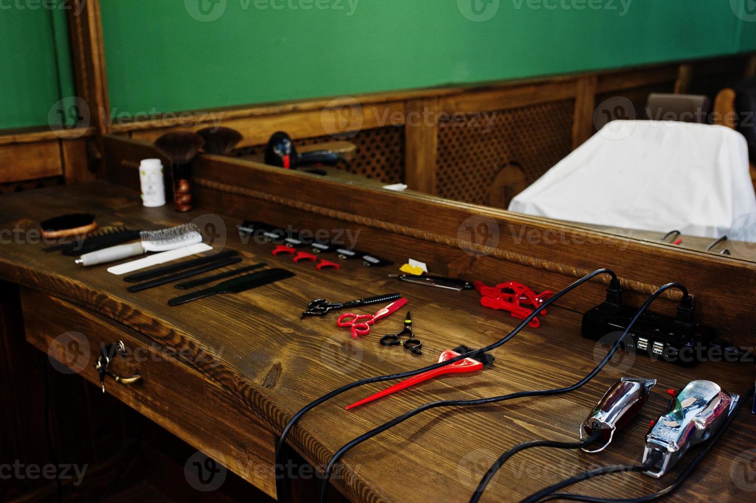 equipo de barbero en la superficie de trabajo junto al espejo de la barbería. foto