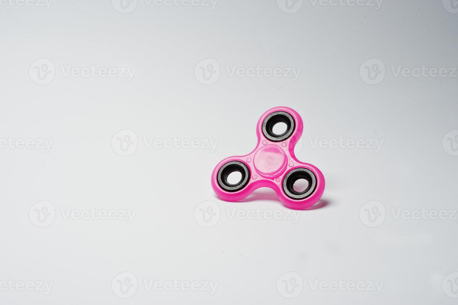 Close-up photo of a pink fidget spinner on a white background.