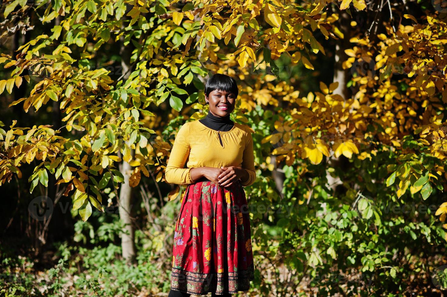 African american girl at yellow and red dress at autumn fall park. photo