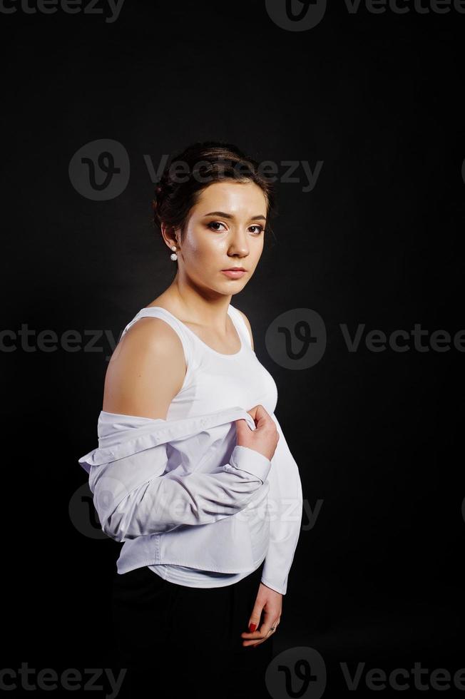 retrato de estudio de una chica morena con maquillaje sobre fondo negro. foto