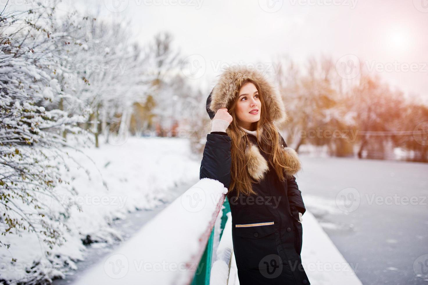 hermosa chica morena en ropa de abrigo de invierno. modelo en chaqueta de  invierno contra el lago congelado en el parque. 8660630 Foto de stock en  Vecteezy