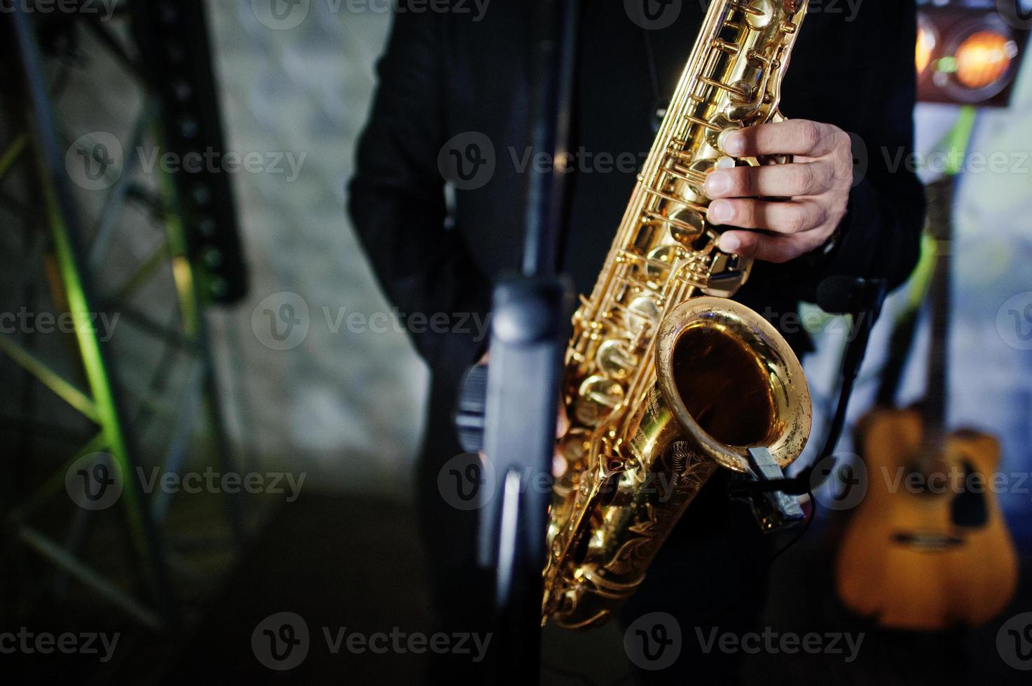 Musicial music live band performing on a stage with different lights. Saxophonist plays. photo