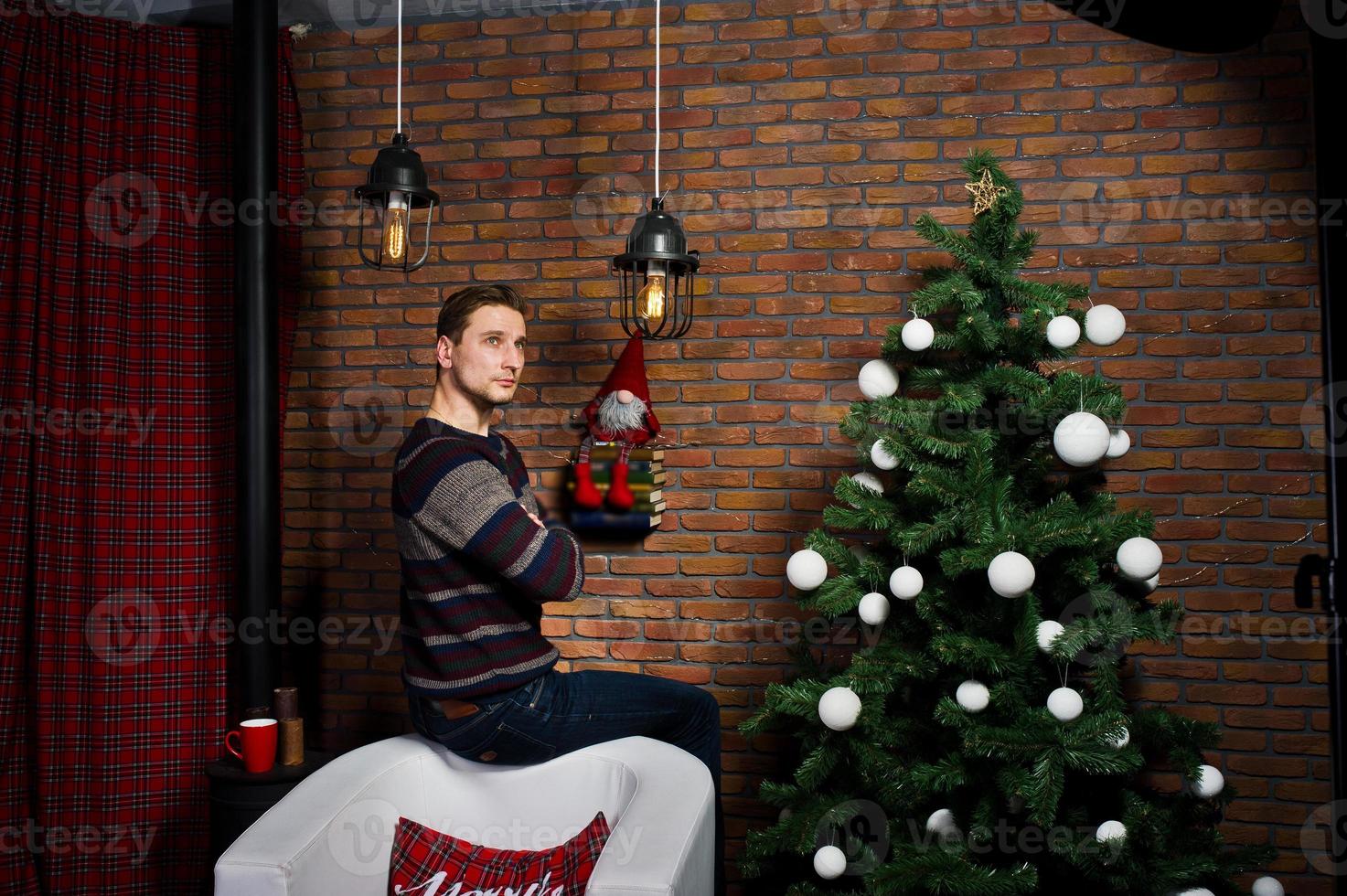 Studio portrait of man against christmass tree with decorations. photo