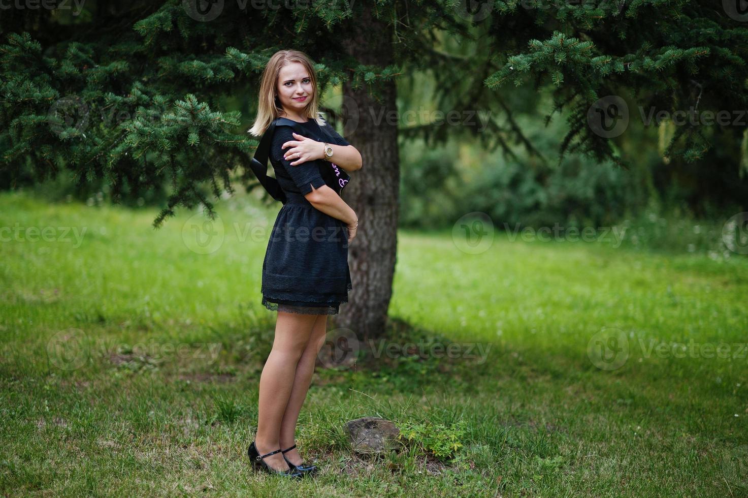 Portrait of gorgeous girl wear on black at hen party, posed at park. photo