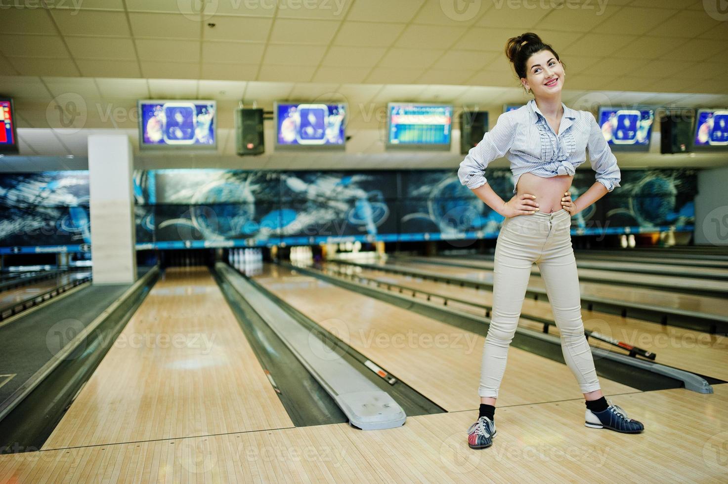 chica con bola de bolos en el callejón jugado en el club de bolos. foto