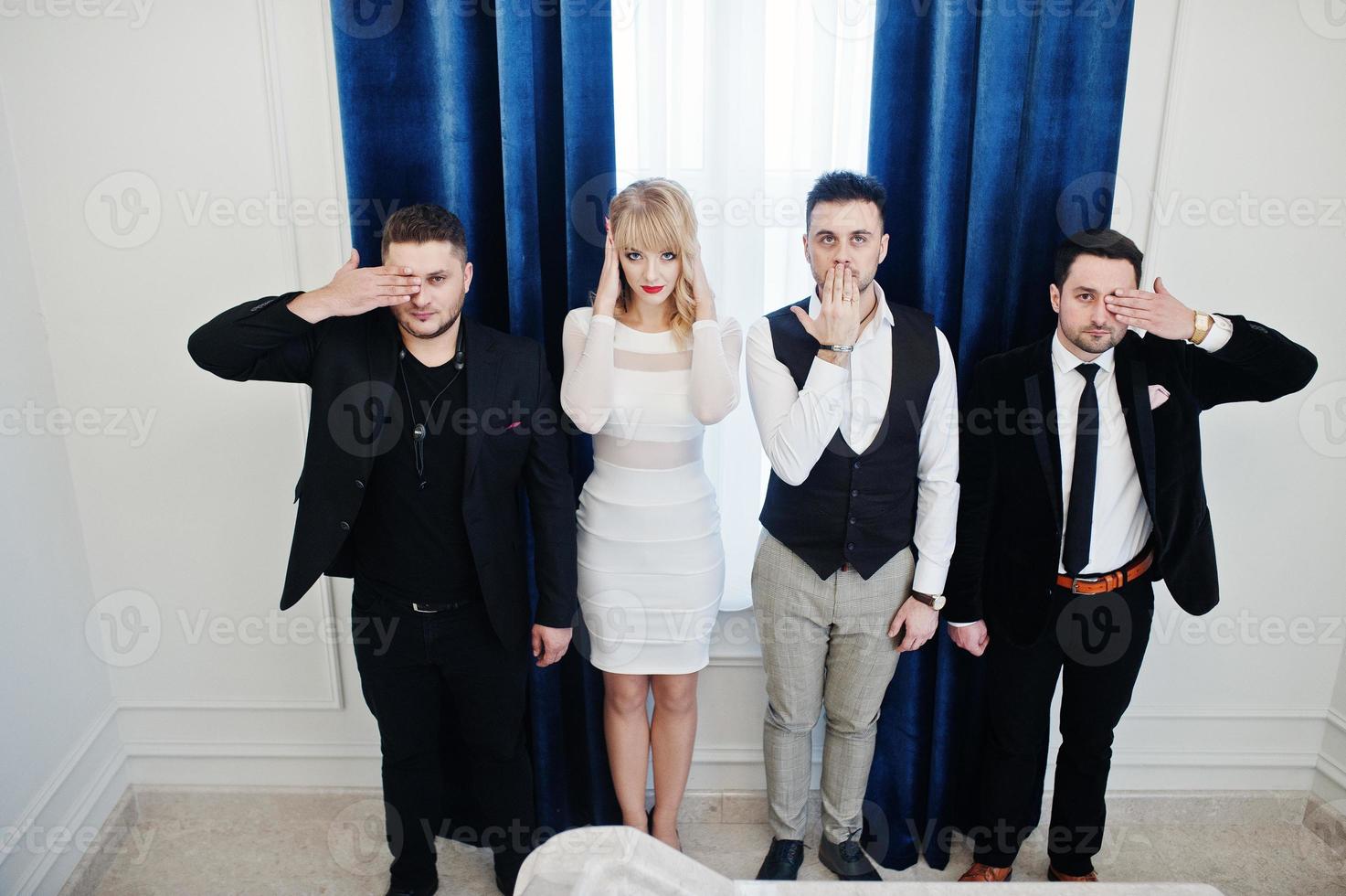 Three stylish bearded man well dressed with one blonde girl in white dress posed. Musician band or singers. photo