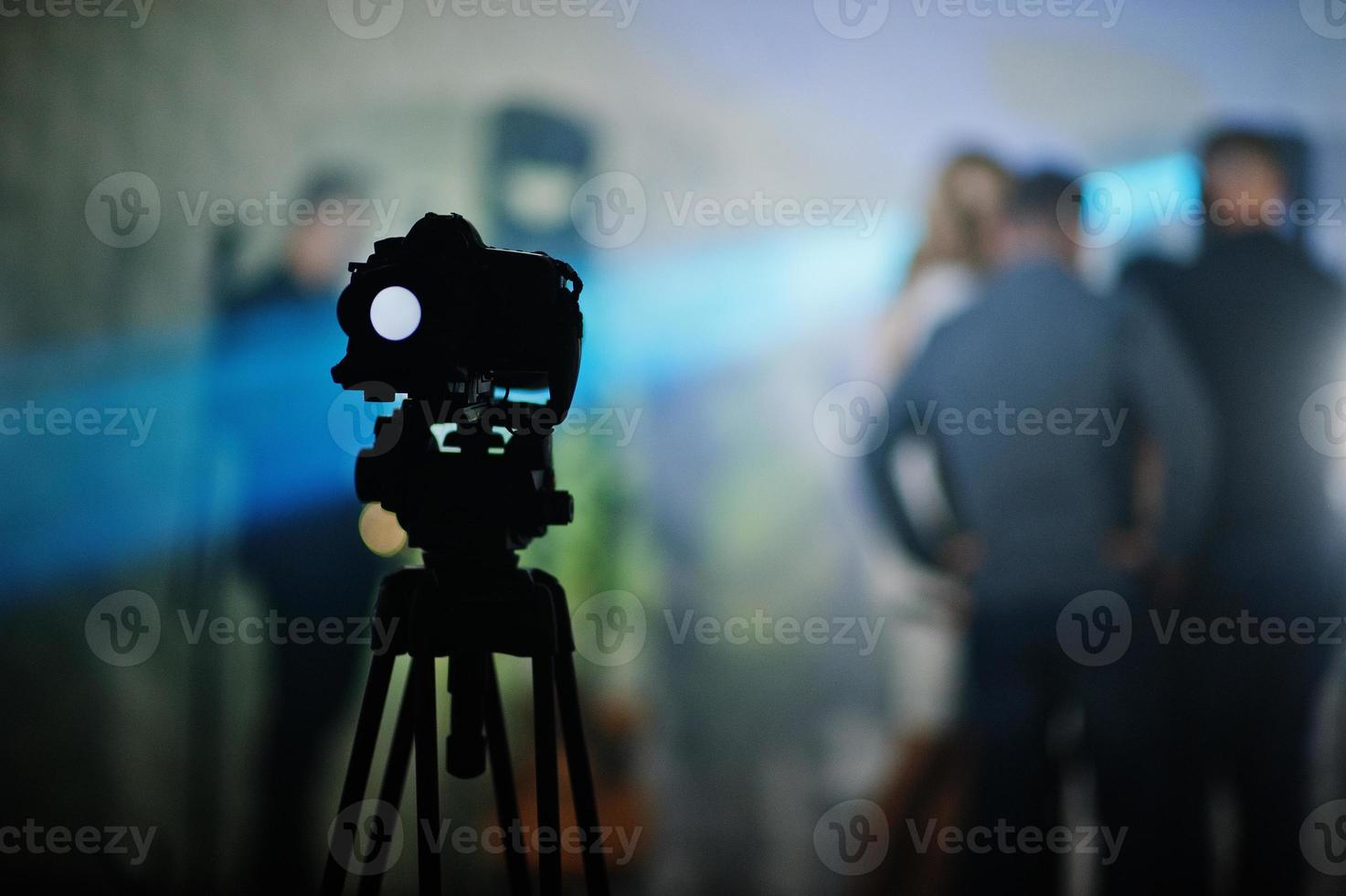 Professional video camera on tripod background people on stage. photo