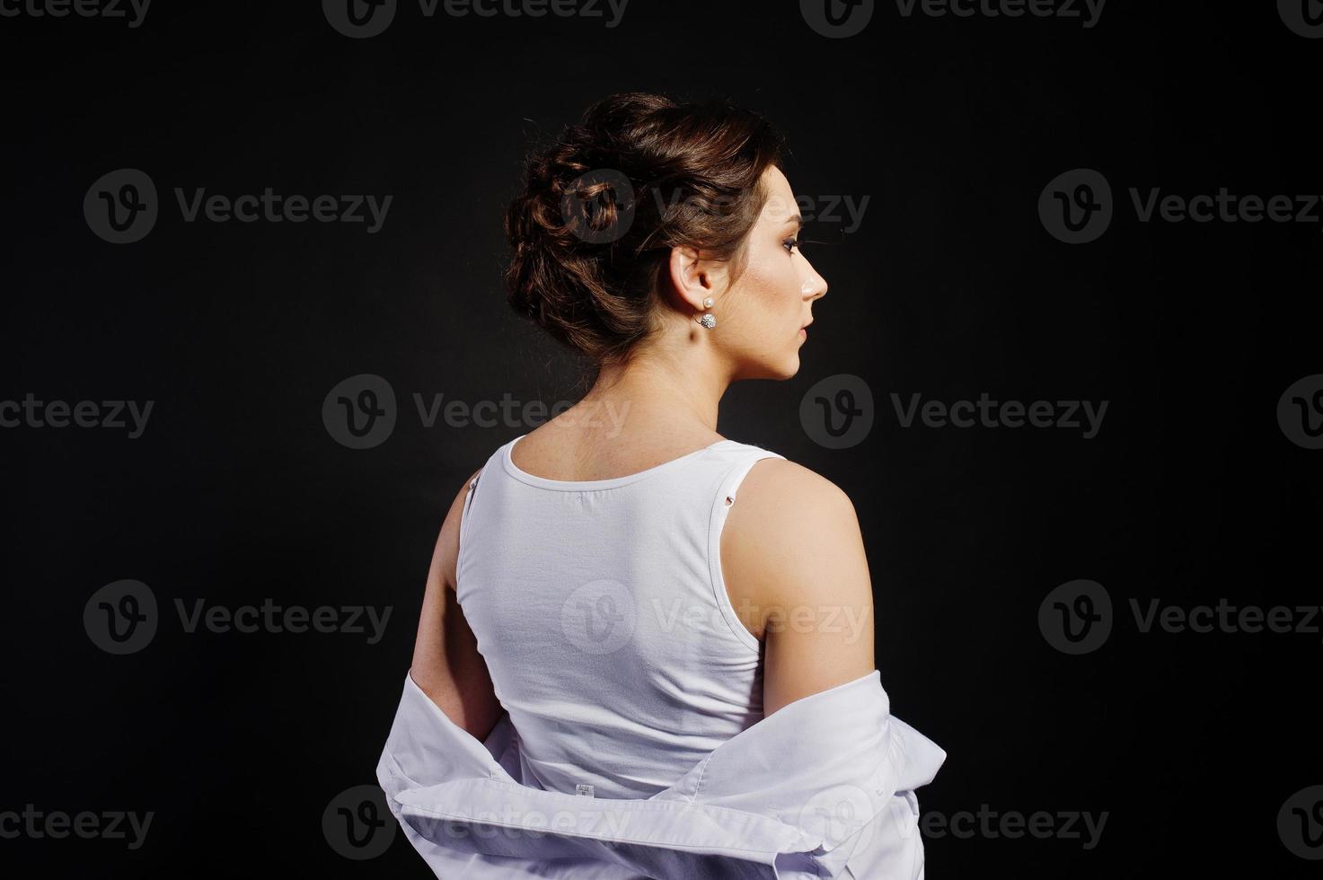 Studio portrait of brunette girl with make up on black background. photo