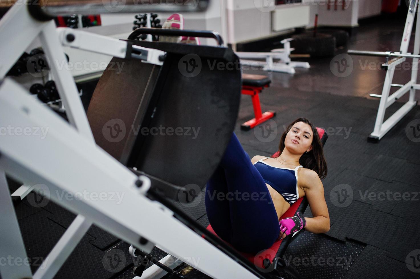 Young beautiful woman doing exercises  and working hard in gym and enjoying her training process. photo