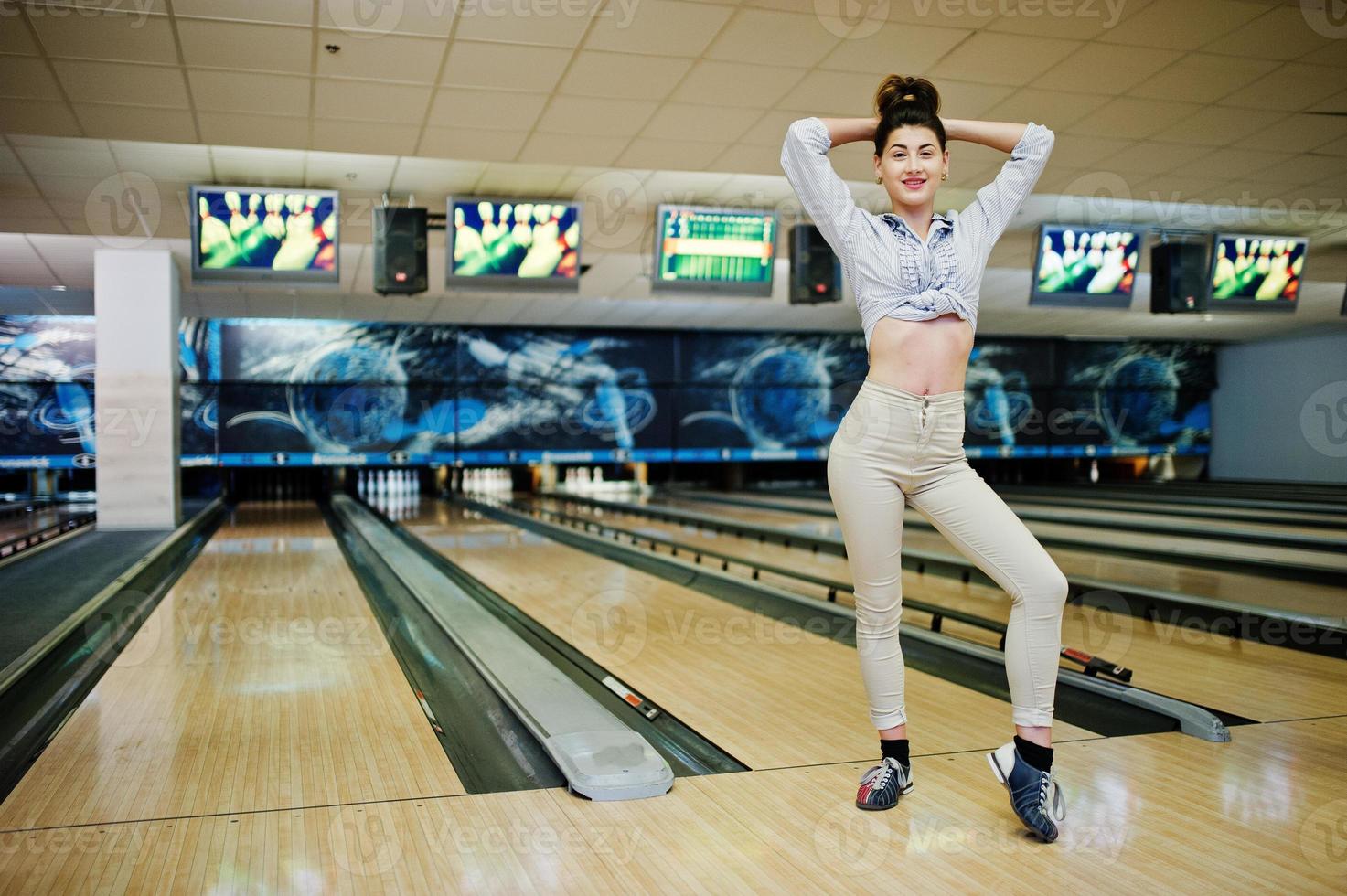 chica con bola de bolos en el callejón jugado en el club de bolos. foto