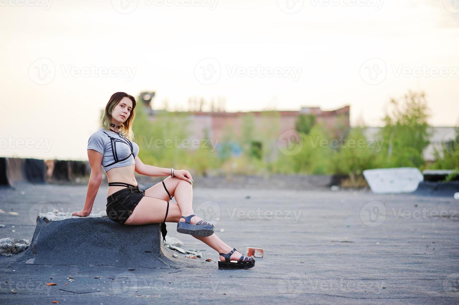 Girl wear on shorts and black erotic fetish underwear at roof. photo