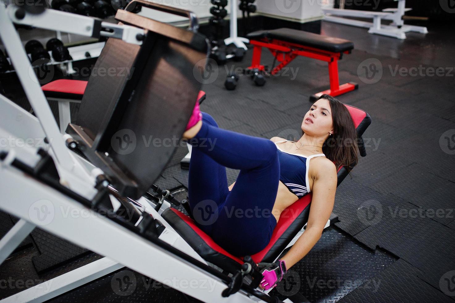 Young beautiful woman doing exercises  and working hard in gym and enjoying her training process. photo
