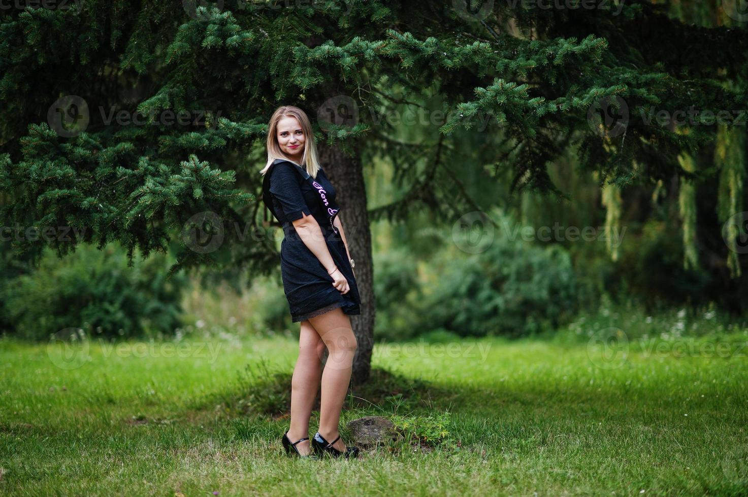 Portrait of gorgeous girl wear on black at hen party, posed at park. photo