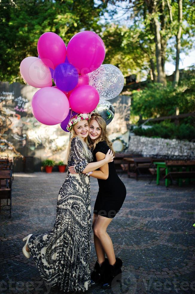 Two girls wear on black with balloons at hen party. photo