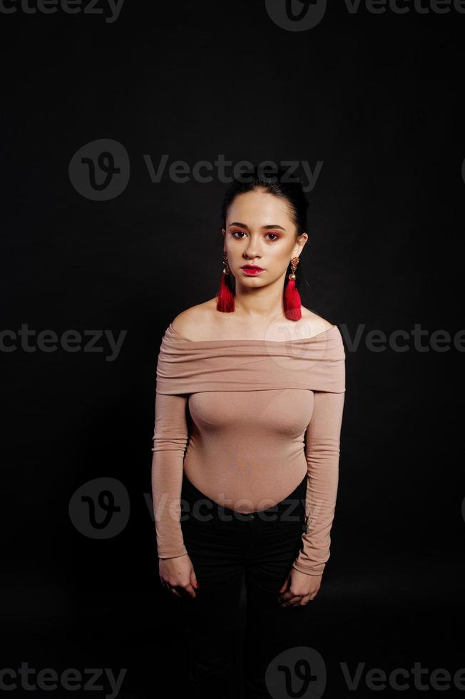 Studio portrait of brunette girl with make up on black background. photo