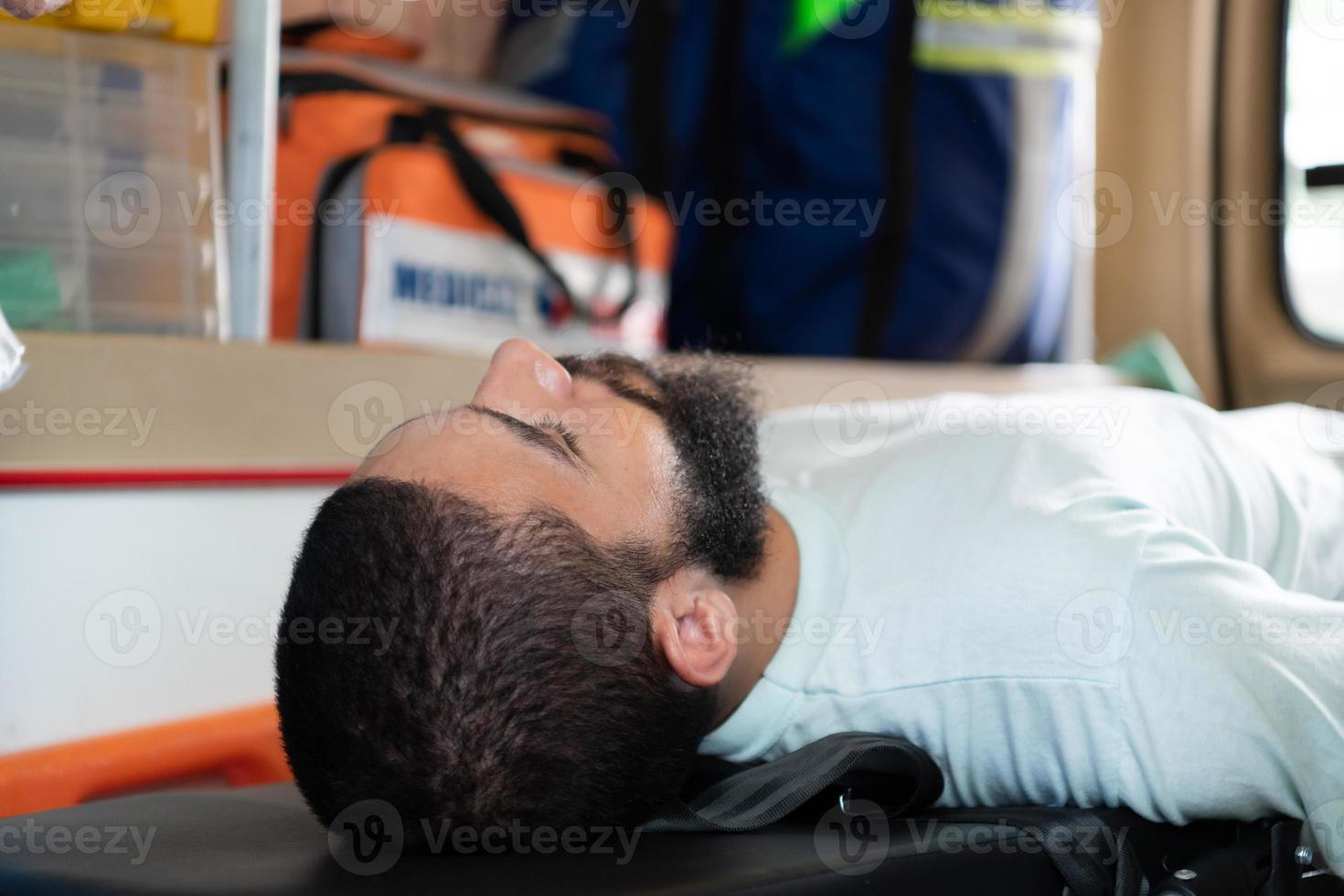 First aid assistance of the ambulance medical team with CPR method and hand-squeezed breathing apparatus photo