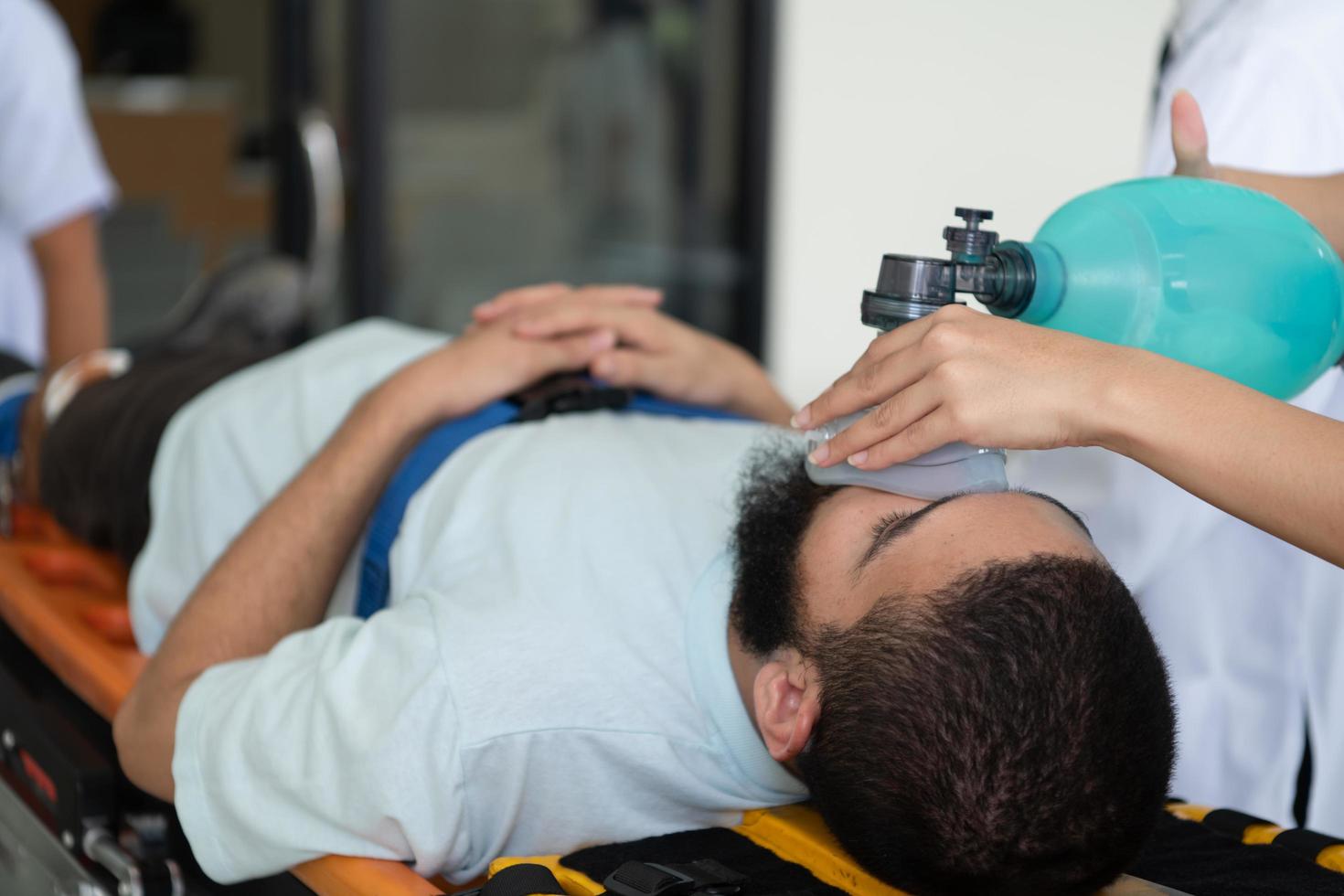 First aid assistance of the ambulance medical team with CPR method and hand-squeezed breathing apparatus photo