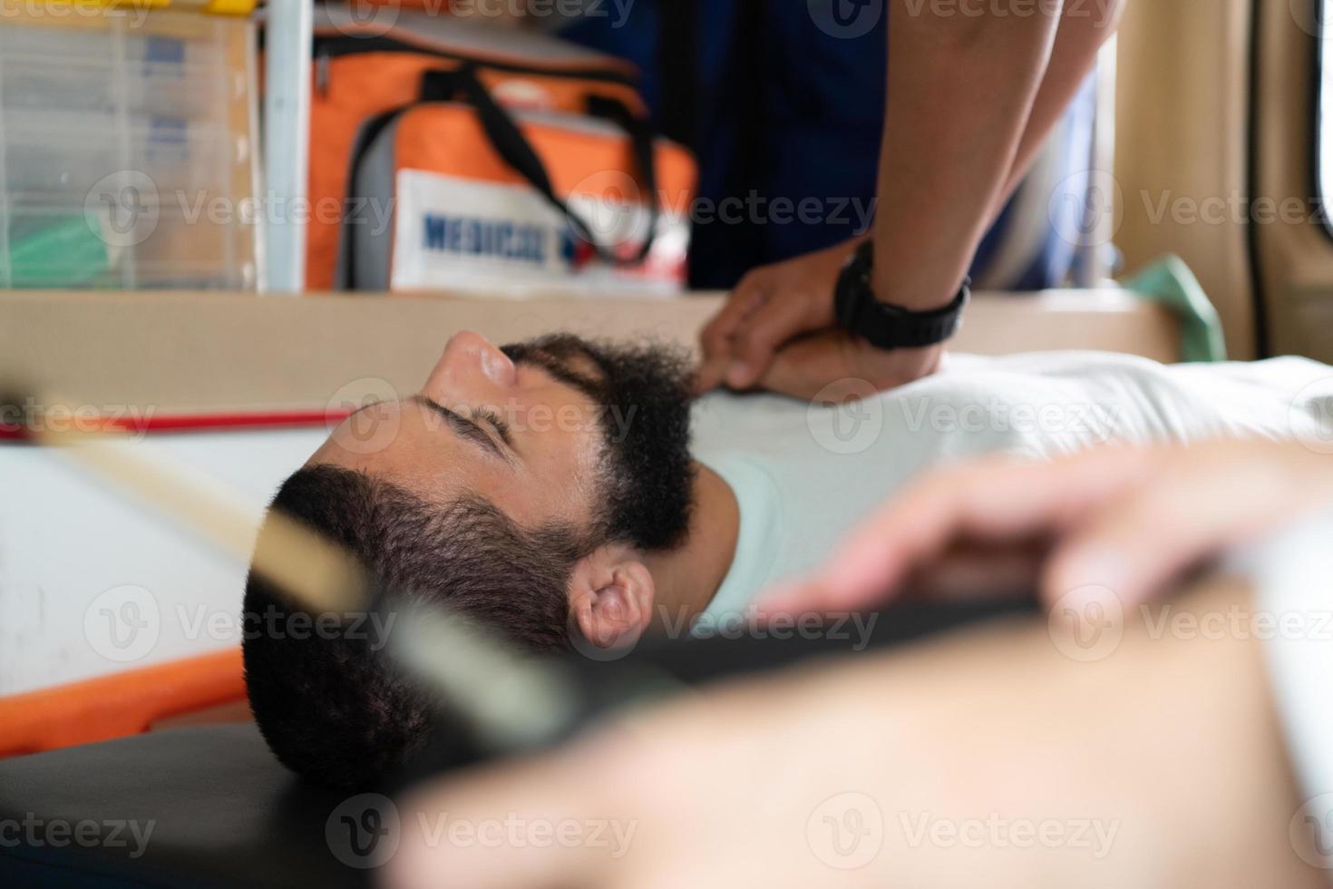 First aid assistance of the ambulance medical team with CPR method and hand-squeezed breathing apparatus photo