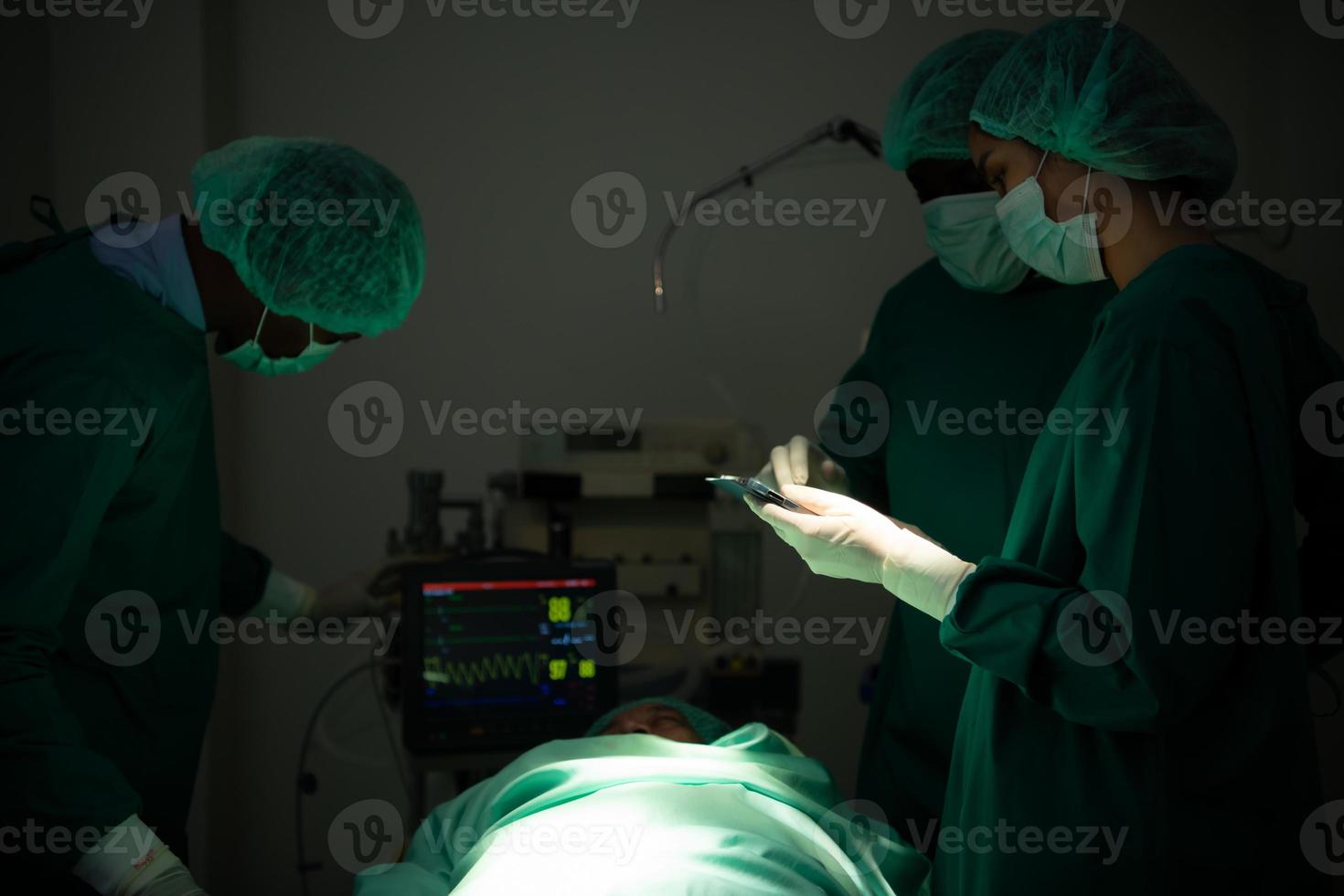 el médico está discutiendo el caso con una tableta. antes de ir a la cirugía en el paciente real foto