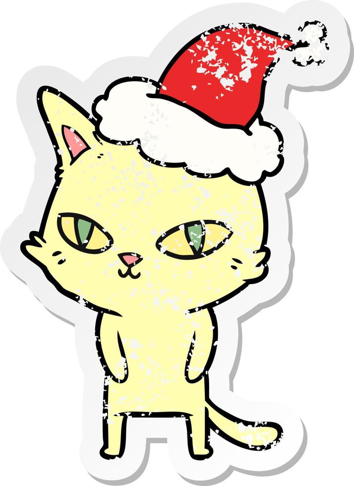 distressed sticker cartoon of a cat with bright eyes wearing santa hat vector