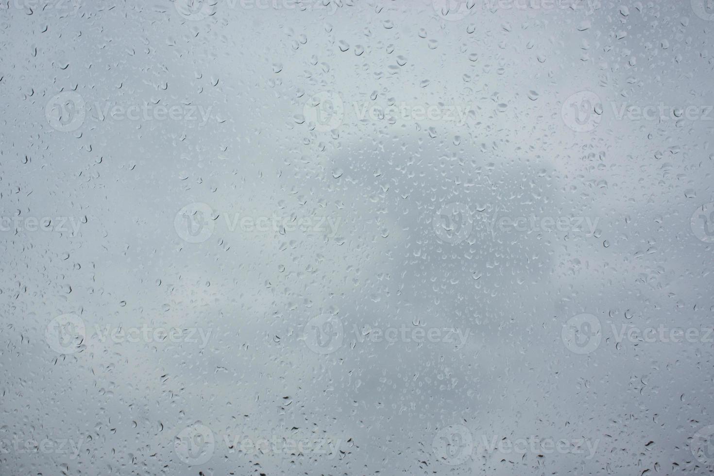 texture of bokeh drops on glass in front of sky photo