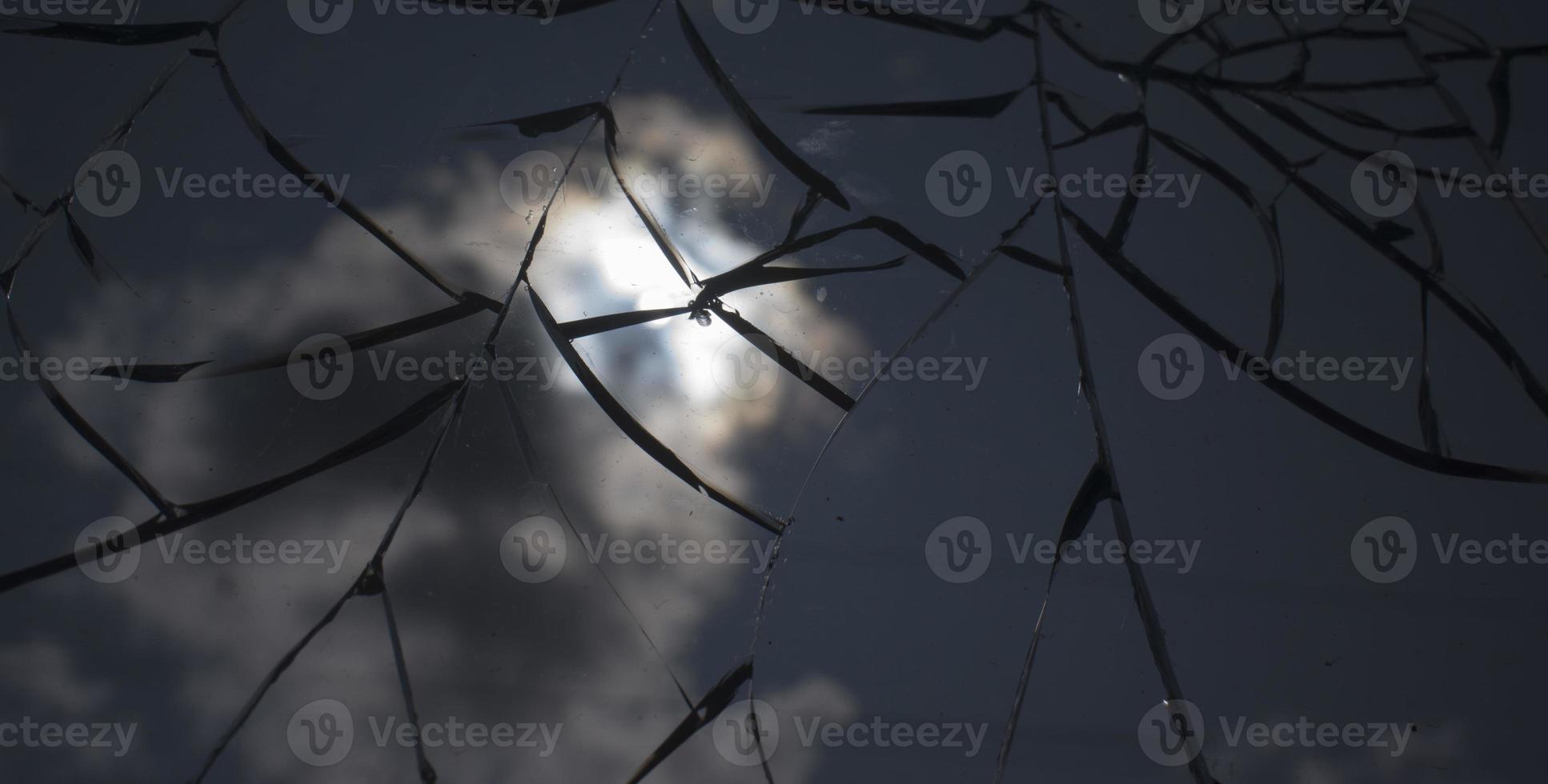 Broken glass over sky and sun behind the cloud background. photo